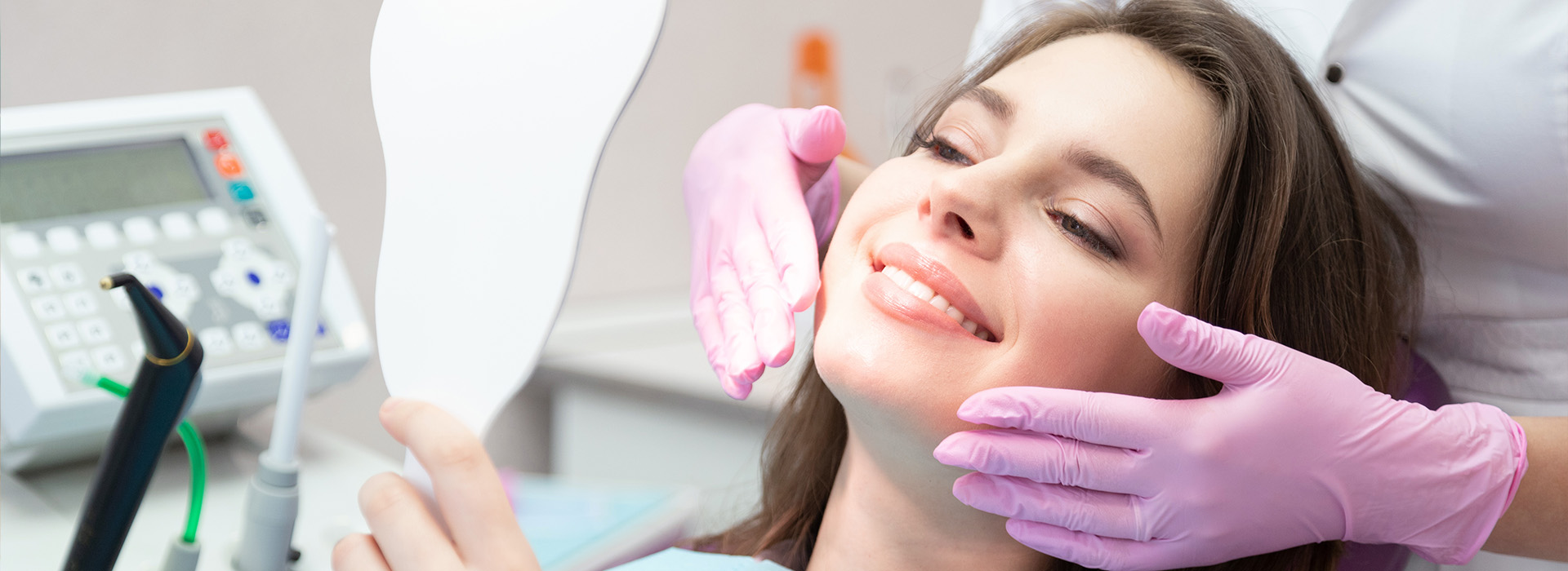 A woman receiving dental care, with a dentist working on her teeth and a medical device in use.