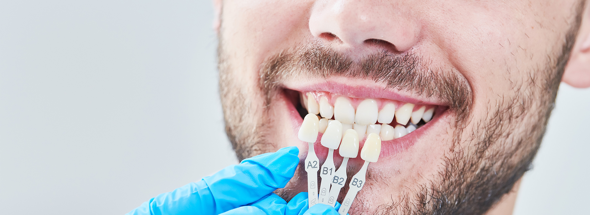 A man receiving dental treatment, with a toothpick inserted in his mouth and a dental tool being used by a professional.