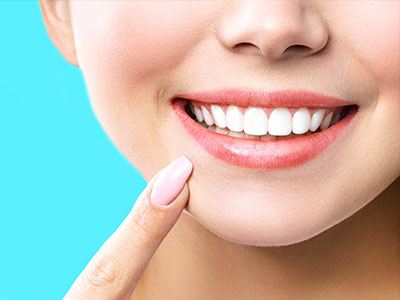 A close-up of a person s face with a bright smile, showcasing their teeth and skin.